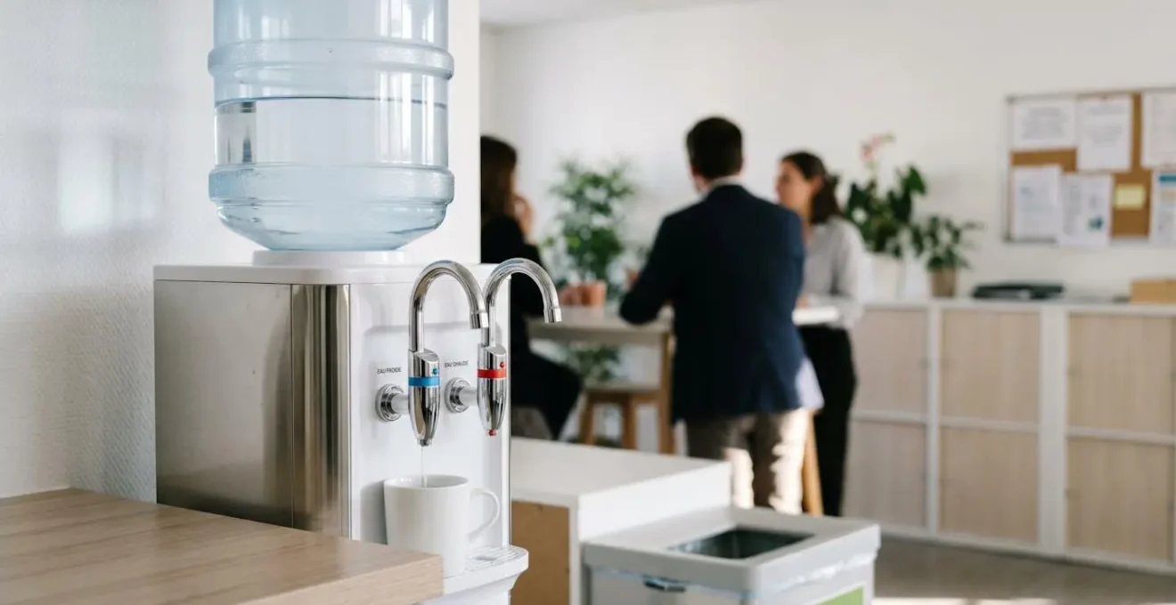 Fontaine à eau à bonbonne moderne avec distributeurs chaud et froid visible dans un espace de bureau français contemporain sur fond blanc